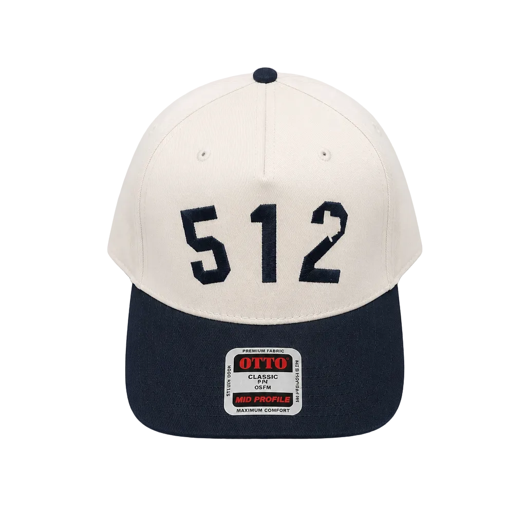 A structured baseball cap with an off-white crown and a navy blue visor, featuring the number '512' in navy on the front. The brim has a visible 'OTTO Classic OTT' brand patch.